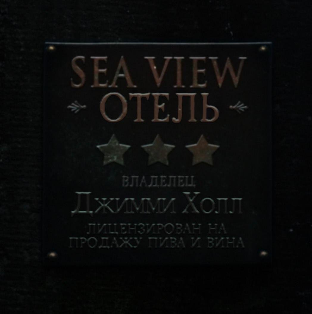 Скриншот из русскоязычного трейлера игры с надписью "Sea View Отель / Владелец Джимми Холл / Лицензирован на продажу пива и вина"