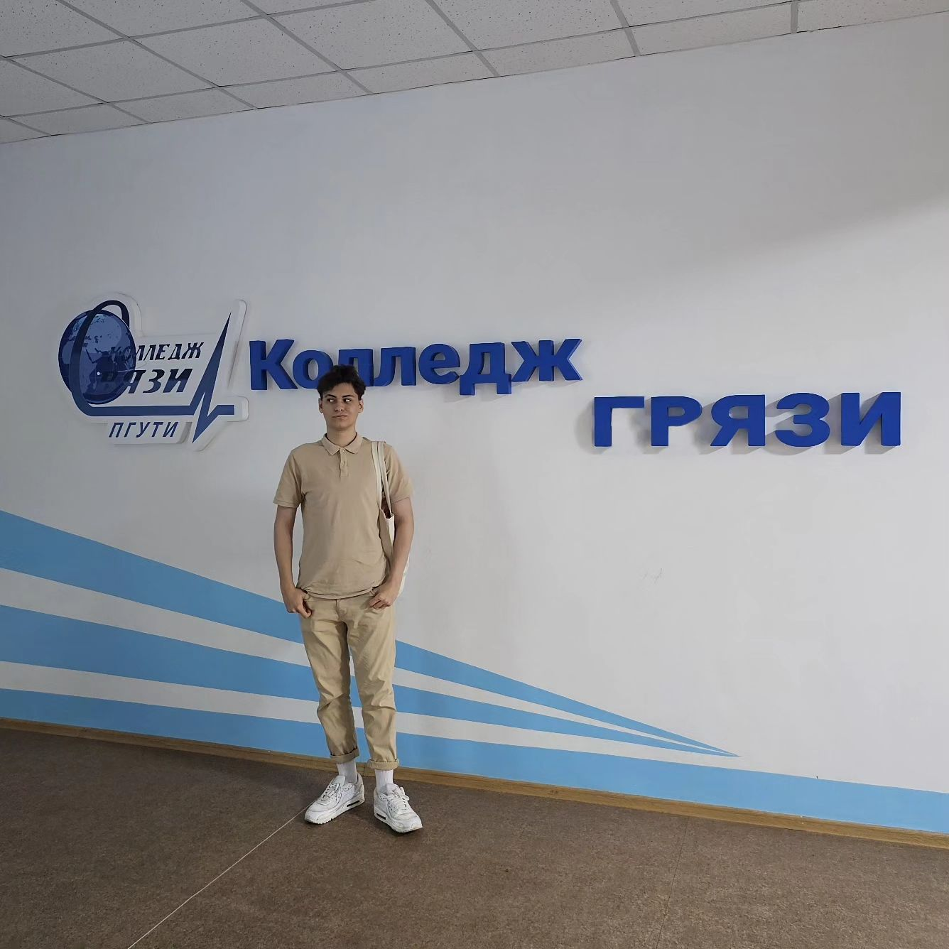 Я на фоне слов "Колледж грязи" на стене
